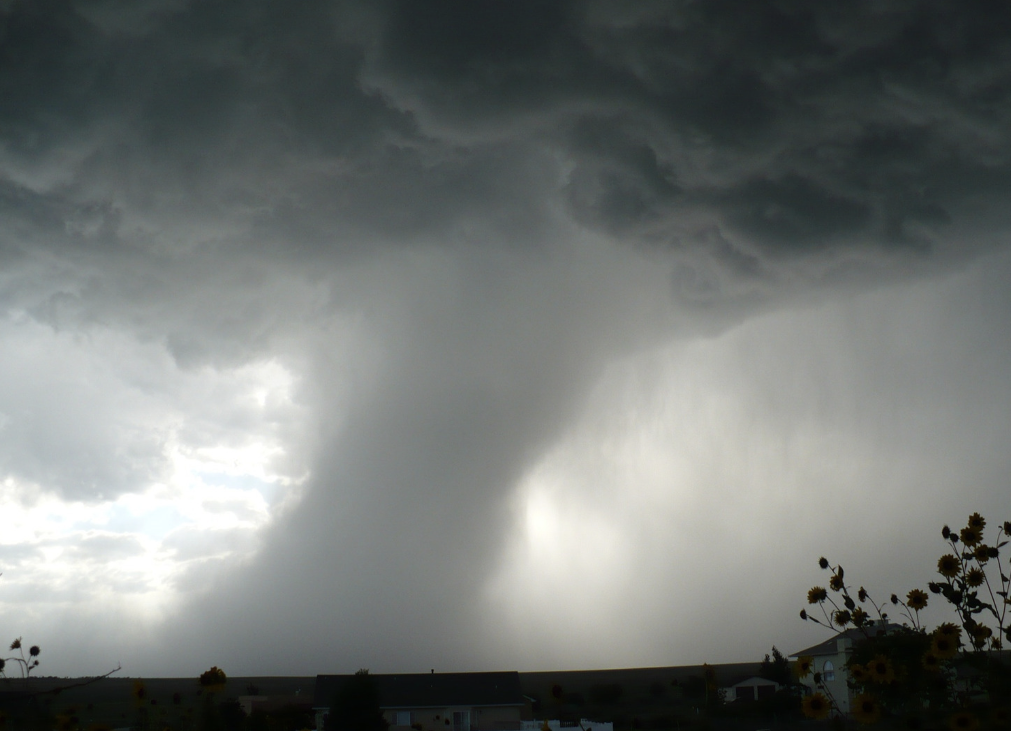 Photo of a massive cyclone looming over houses