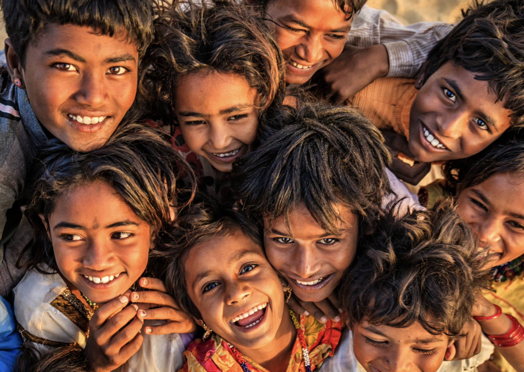 Photo of tight group of smiling children shot from above