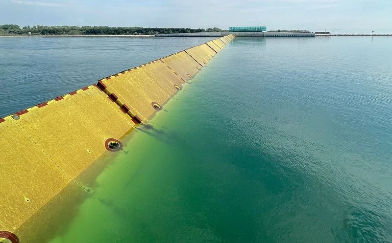 Set of storm barriers submerged in water blocking storm surge to protect community