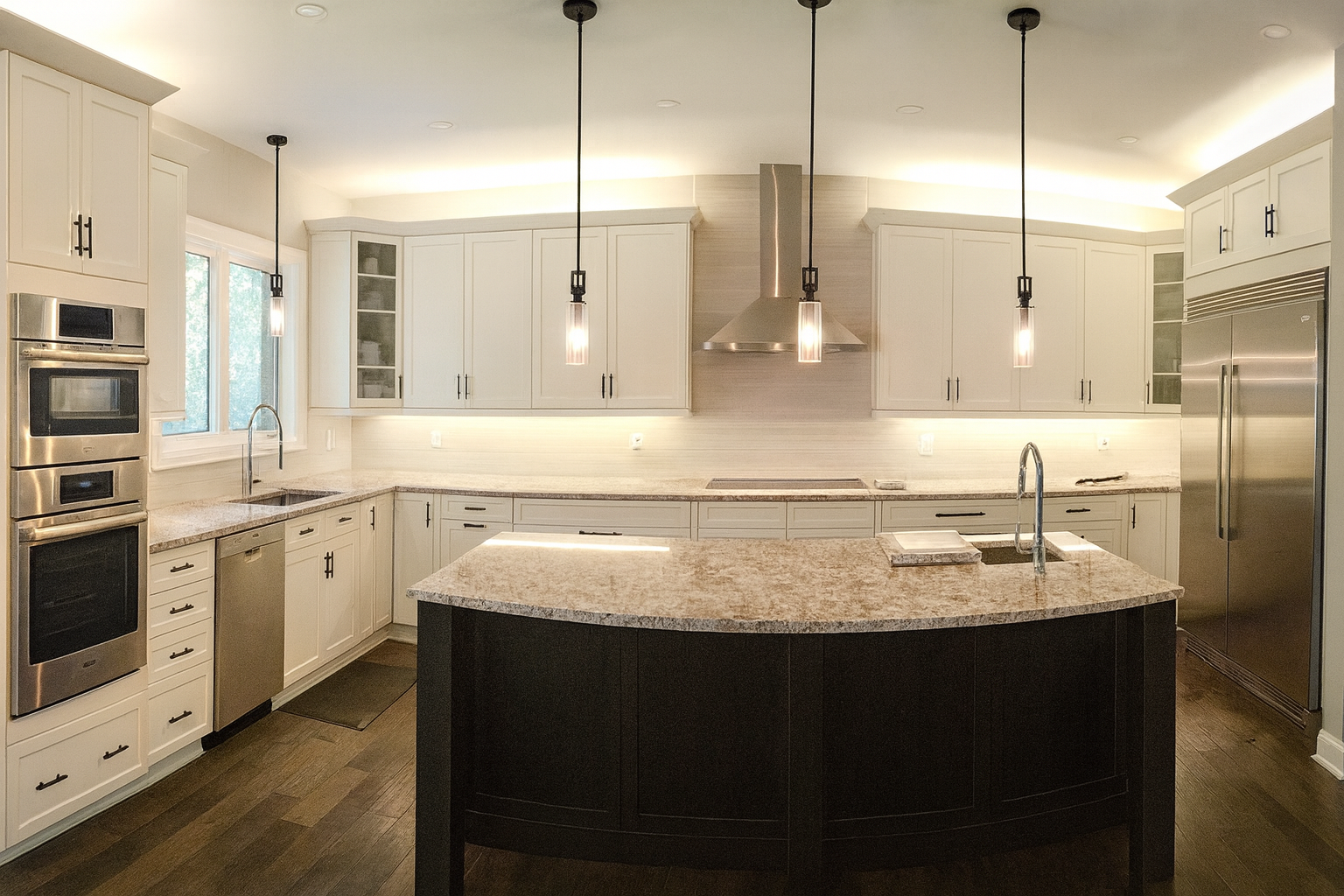 Modern kitchen with white cabinets, stainless steel appliances, and a central island with a granite countertop. Pendant lights hang over the island, and there is under-cabinet lighting along the walls.