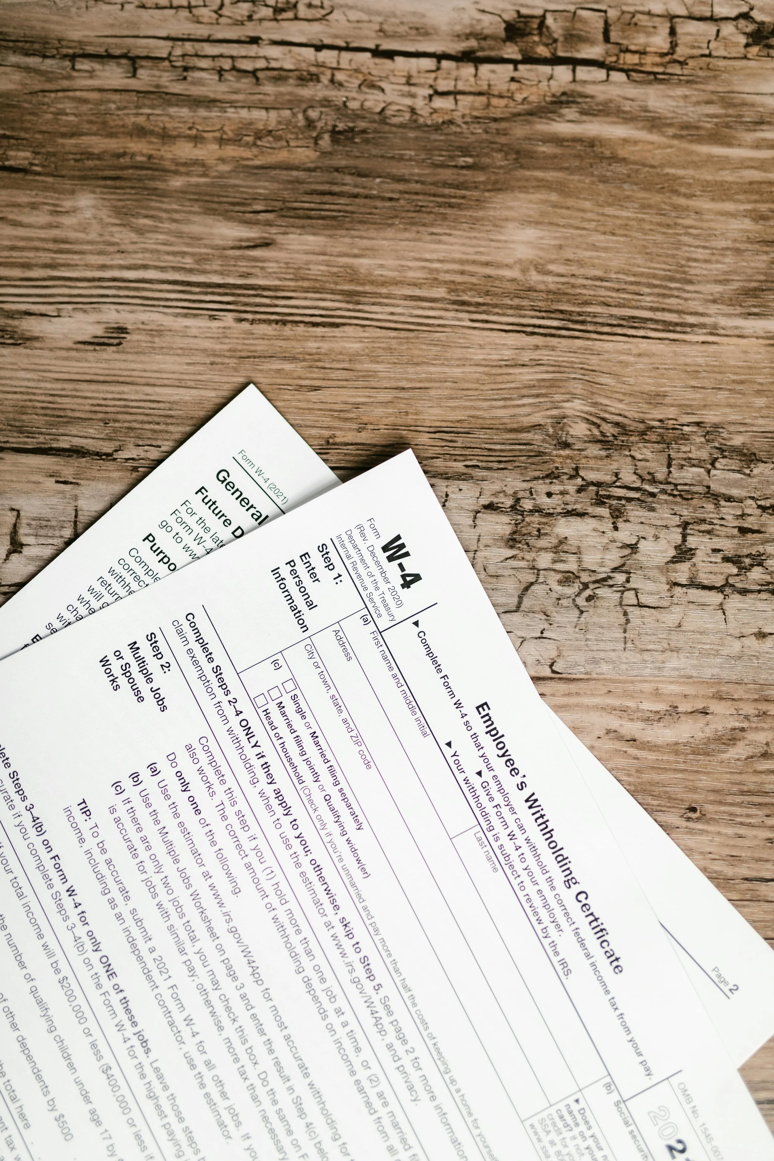 Tax forms placed on a wooden surface, including a W-4 form.