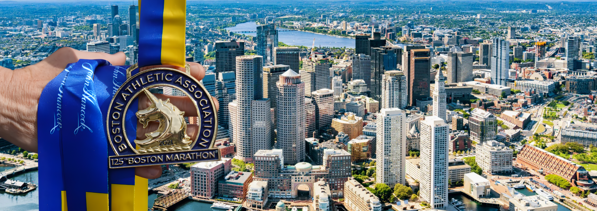 A medal for the 125th Boston Marathon hanging from a ribbon with a view of downtown Boston skyline and waterfront.
