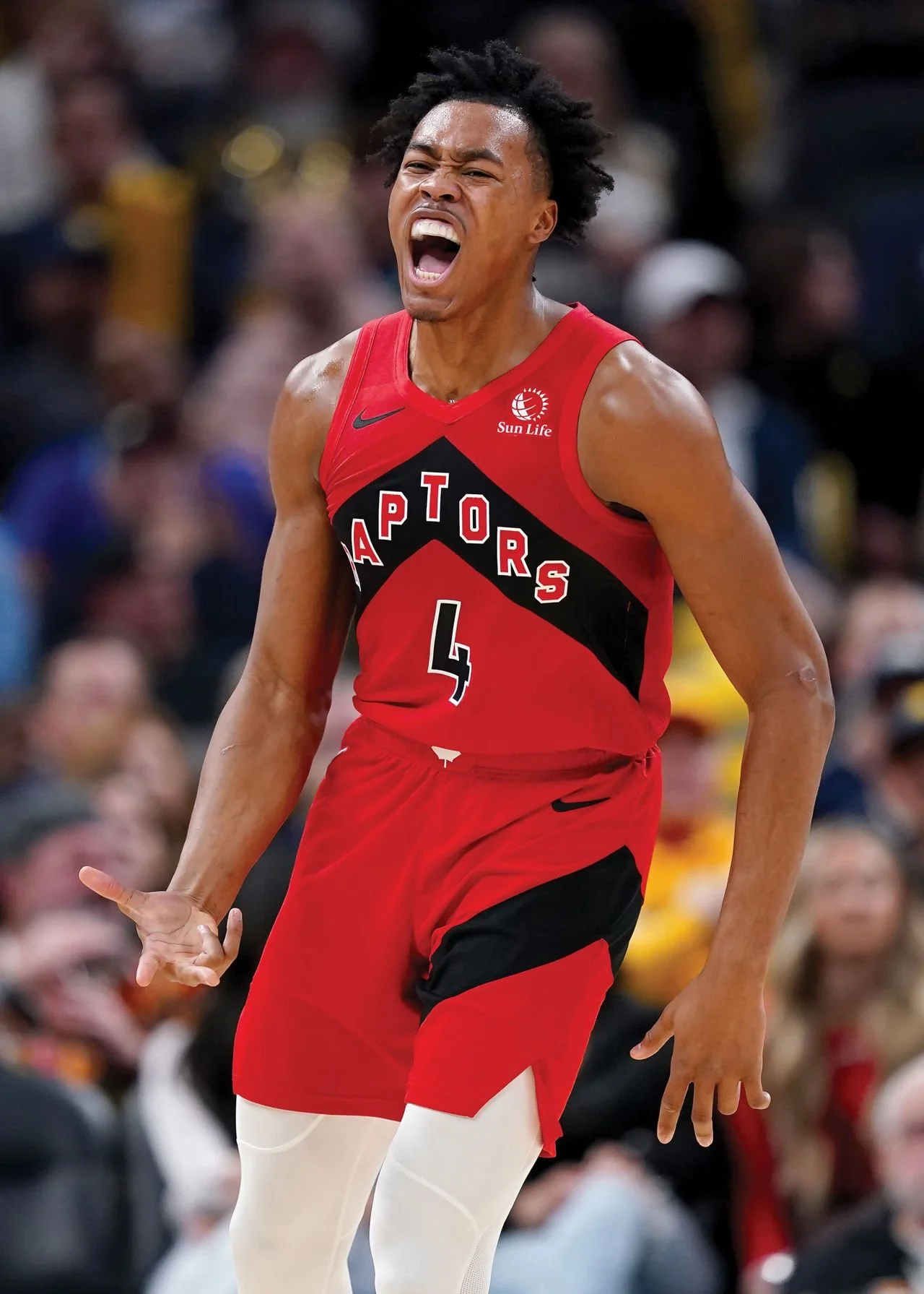 A basketball player in a Toronto Raptors jersey with number 4, celebrating during a game.