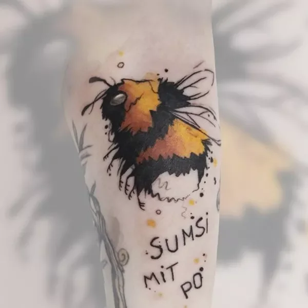 Tattoo eines Bienenmotivs mit dem Text 'SUMSI MIT PO' darunter.