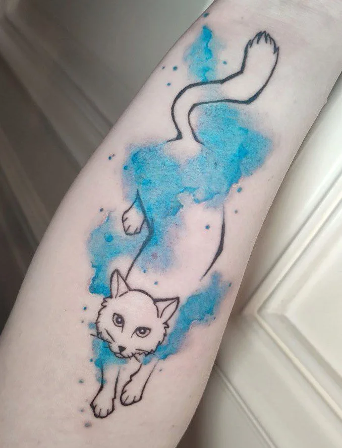Tattoo einer Katze mit blauer Aquarell-Optik auf dem Arm.