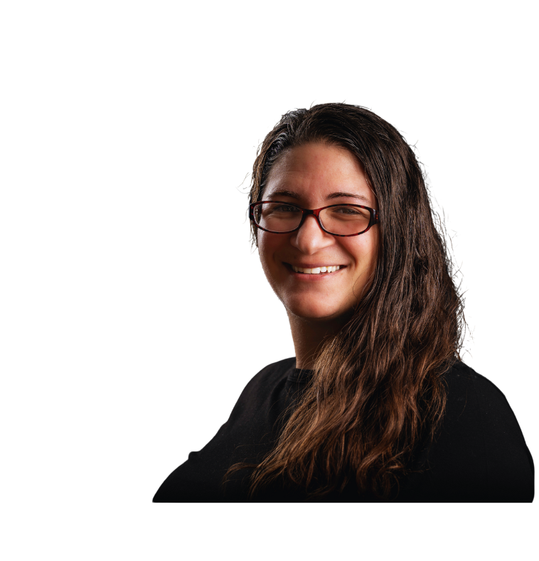 Elizabeth Horst CEO and co-founder of Elizabeth's Writing Corner, a woman with long wavy brown hair, wearing glasses and a black shirt, smiling at the camera against a black background.