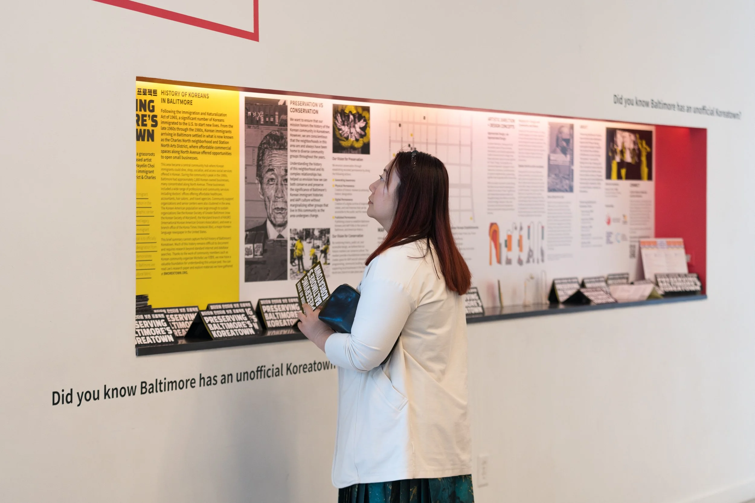 Woman of Chinese descent looks at informational panels about Preserving Baltimore's Koreatown.