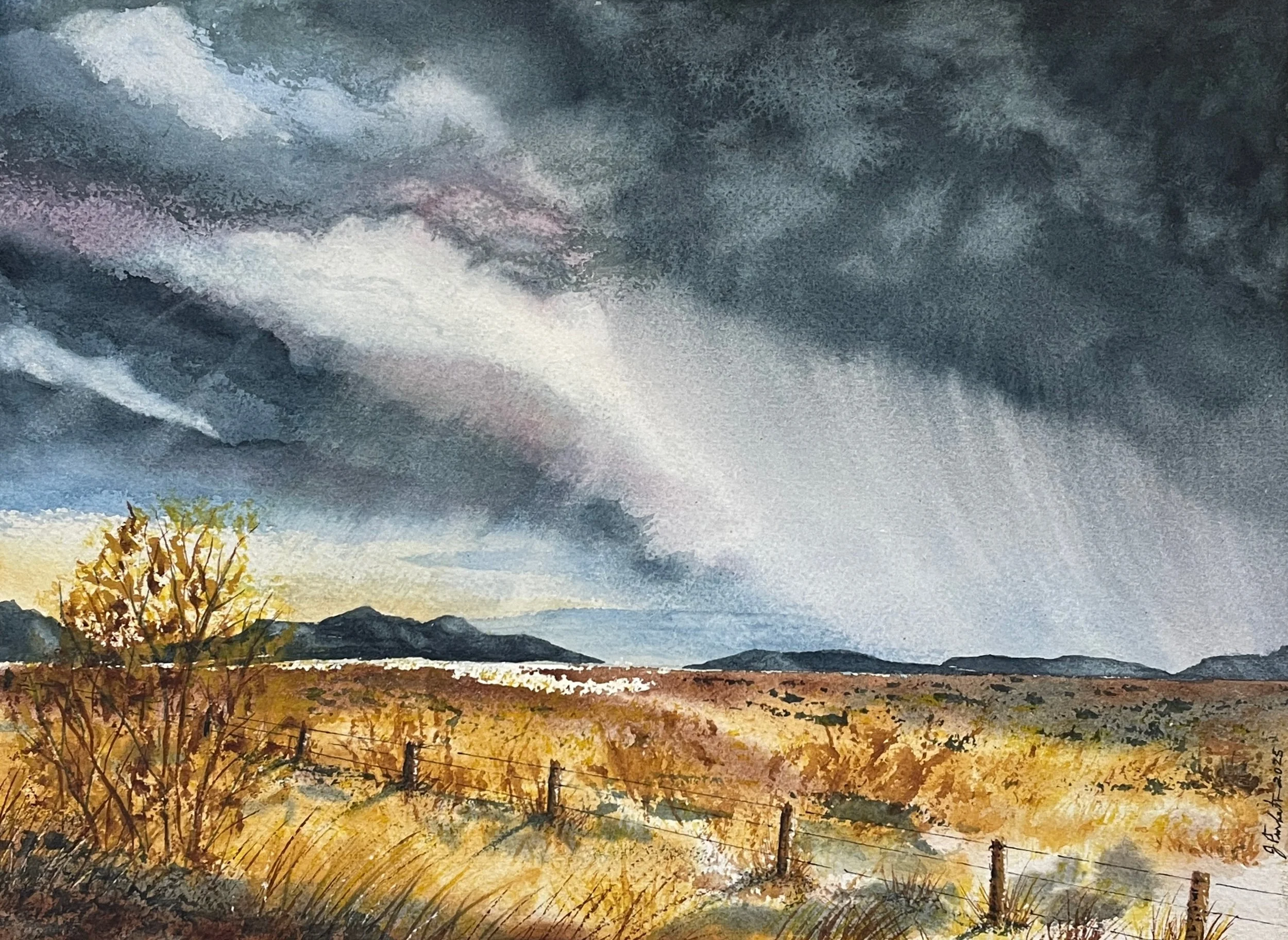 Watercolor painting of a windy western landscape with dark storm clouds, rain falling on distant mountains, a fence, and a tree with autumn leaves.