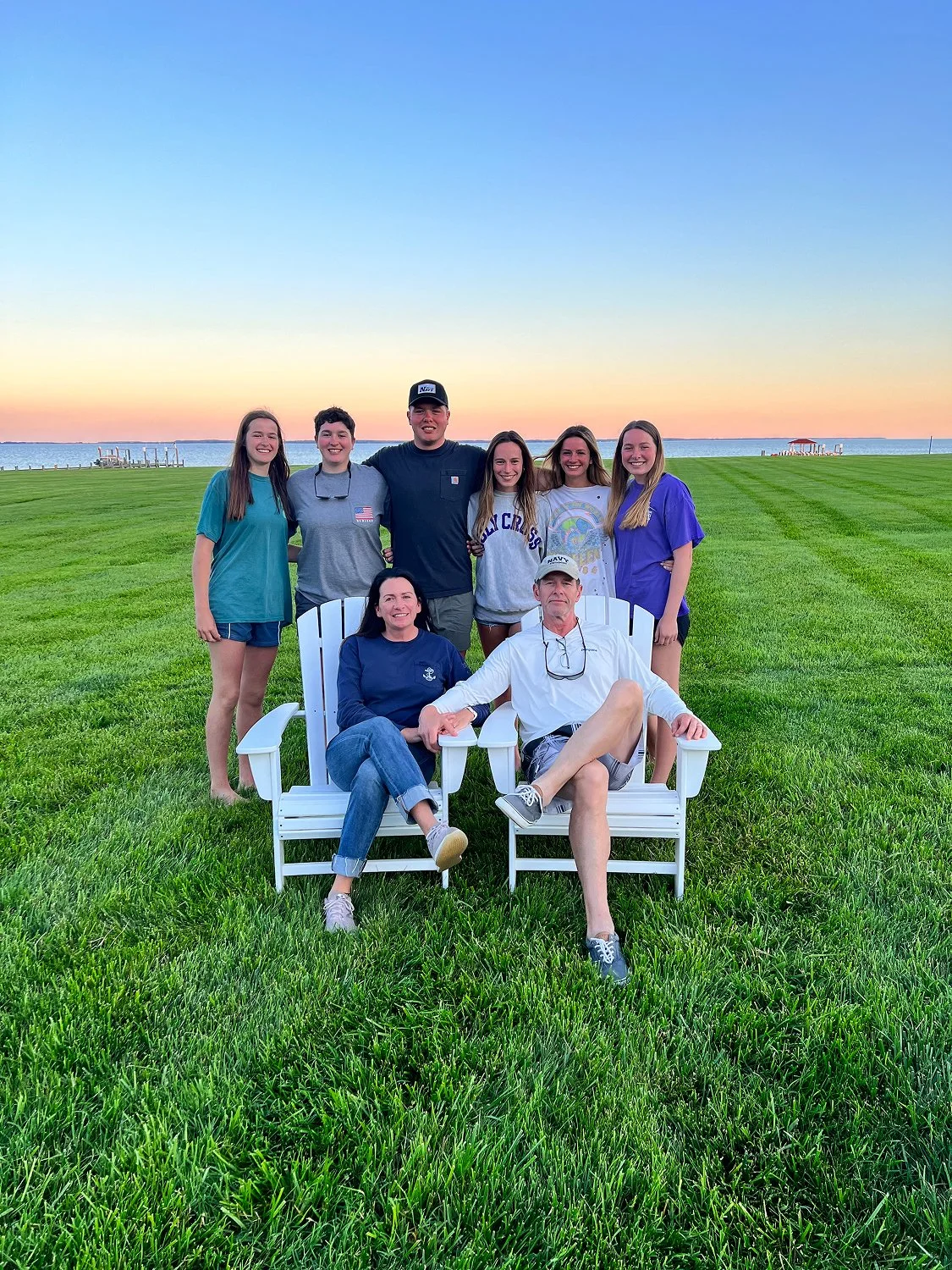 Nancy Lacore and her husband Pat Lacore sit in lawn chairs, surrounded by their six grown children.