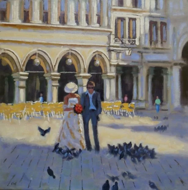 An oil painting of a city square with a historic building featuring arches and balconies, with a couple in vintage attire walking among pigeons, and outdoor café tables in the background.