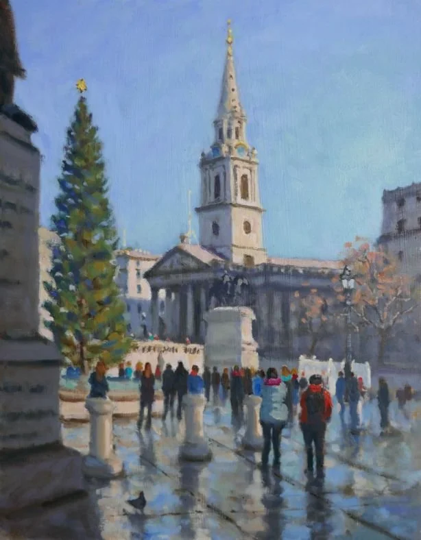 A city square with a tall, ornate church tower in the background, a large decorated Christmas tree on the left, and people walking on a wet pavement, some with umbrellas, during a sunny day.