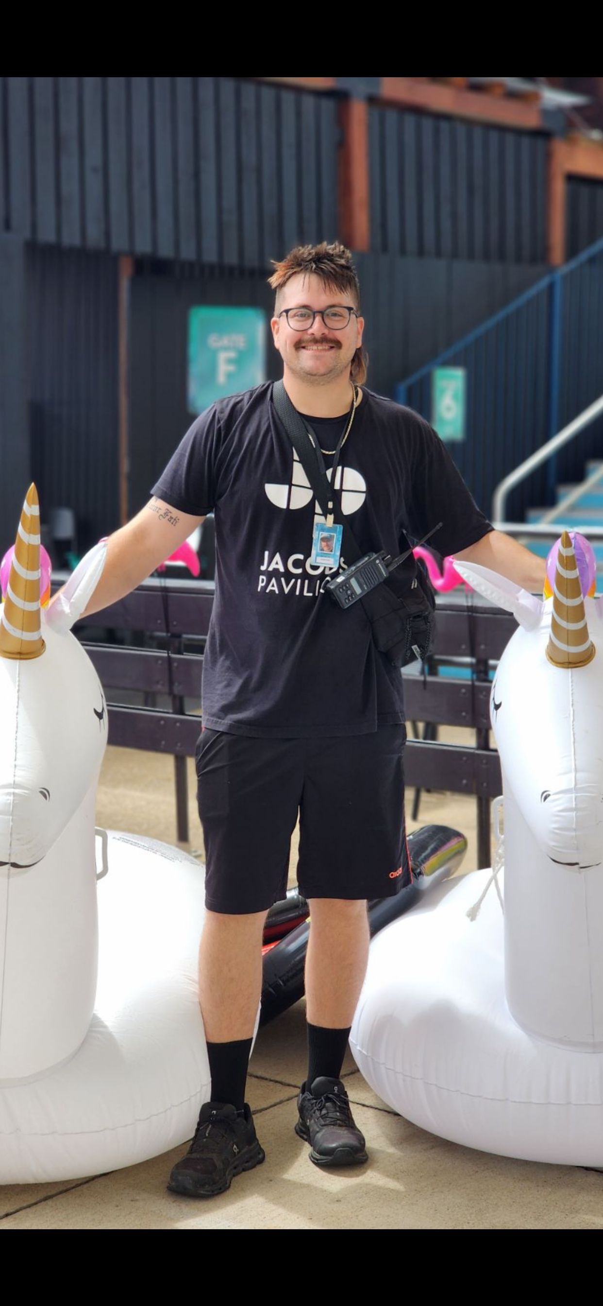 Ambassador Connor on a stage next to two blow up Unicorns