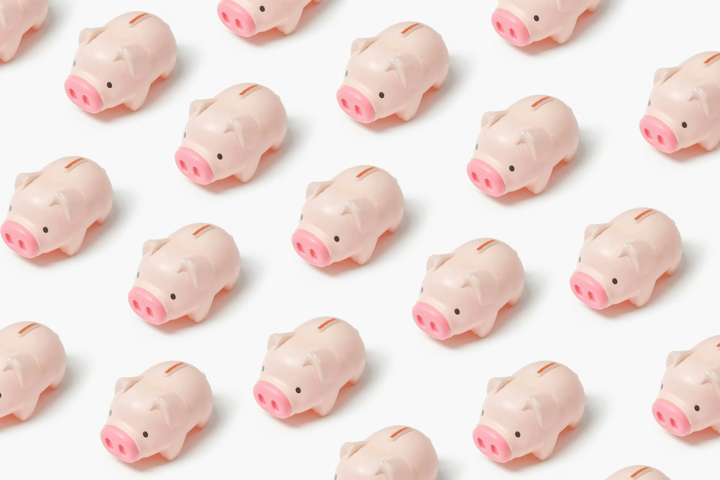 Multiple pink piggy bank figurines arranged in a pattern on a white background.