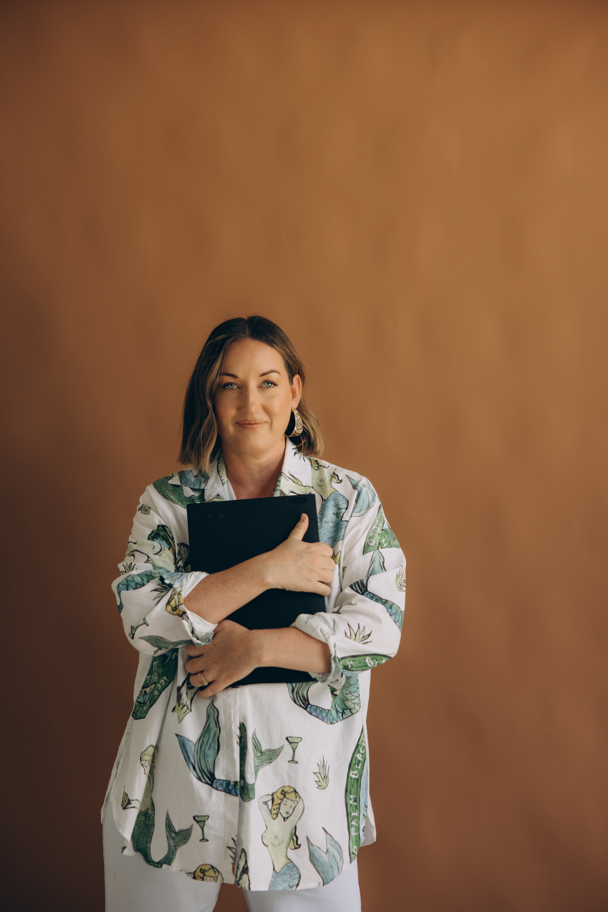 Ash Becker holding a laptop | Owner and Founder CEO of Career Confidence Co. Australia