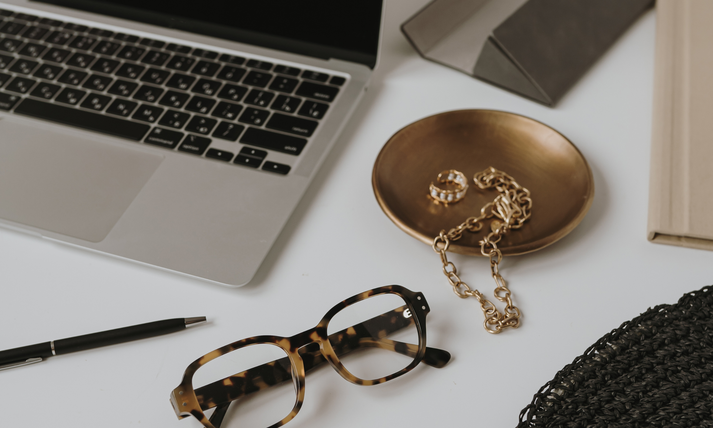 Laptop with jewelery and sunglasses of a success women in career