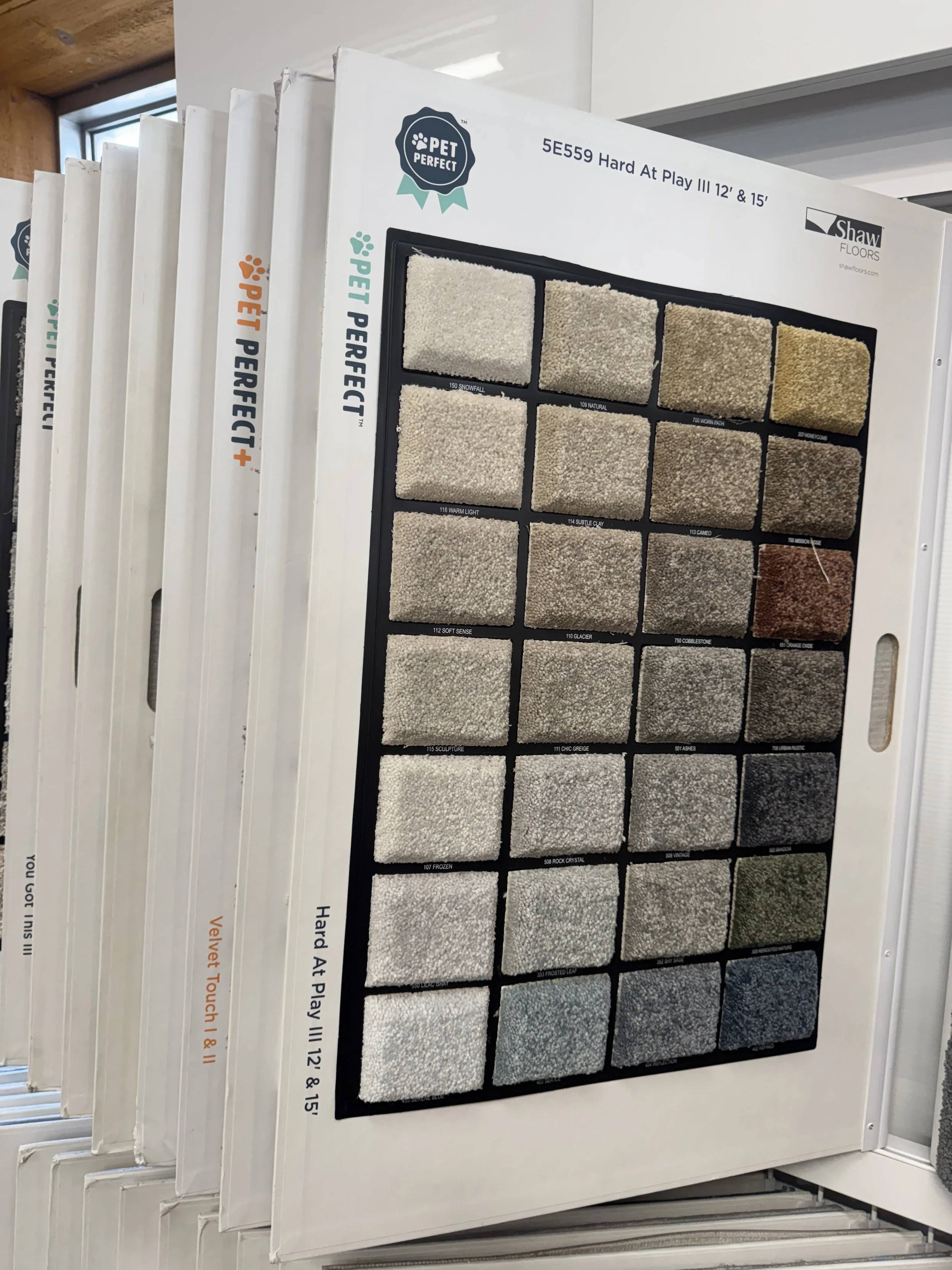 A carpet sample display board showing various carpet textures and colors in a store.