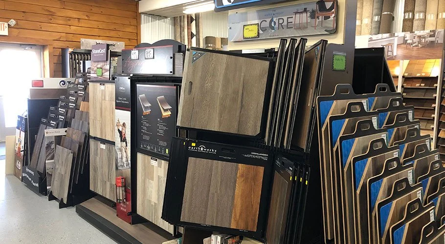Display of various laminate and flooring samples in a store, arranged vertically on racks.