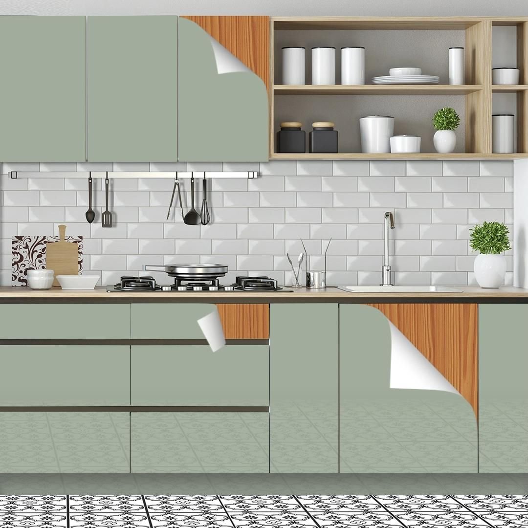 Modern kitchen with green cabinets, open wooden shelves, white subway tile backsplash, black kitchen utensils hanging, gas stove, stainless steel pots, white bowls, potted plants, and patterned black and white floor tiles.