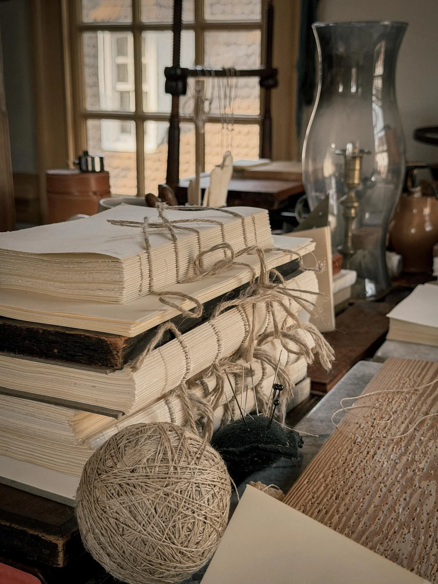 I think some of the most meaningful creative ideas don&rsquo;t arrive while we&rsquo;re trying to think of them.

They appear while moving through an ordinary day.

A worn book pulled from a shelf,
the texture of old paper,
a spool of thread, a stack