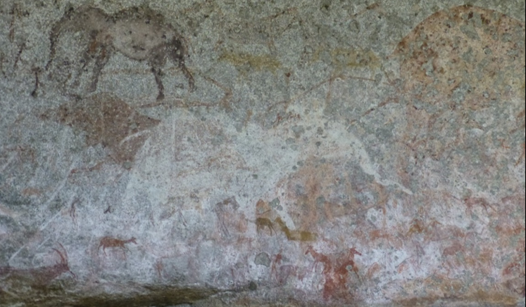 Ancient cave wall paintings of elephants depicted in red and brown pigments.