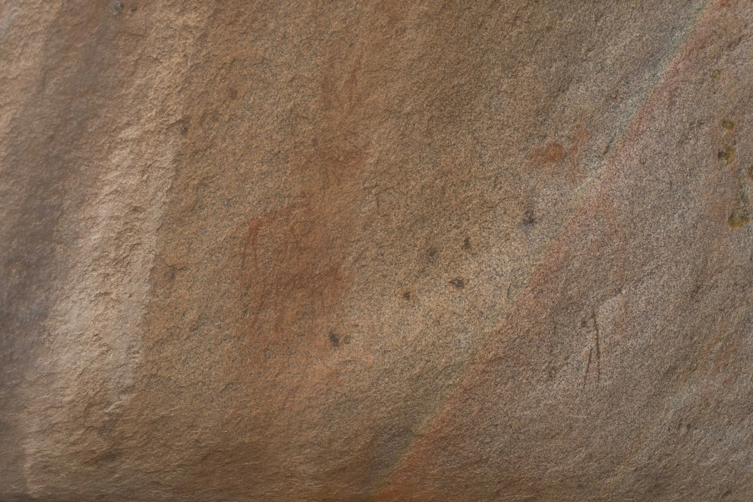 Close-up of a textured, weathered, rusty metal surface with patches of roughness and small blemishes.