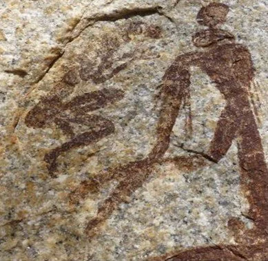 Ancient cave painting of a human figure with jewelry and another in fetus position