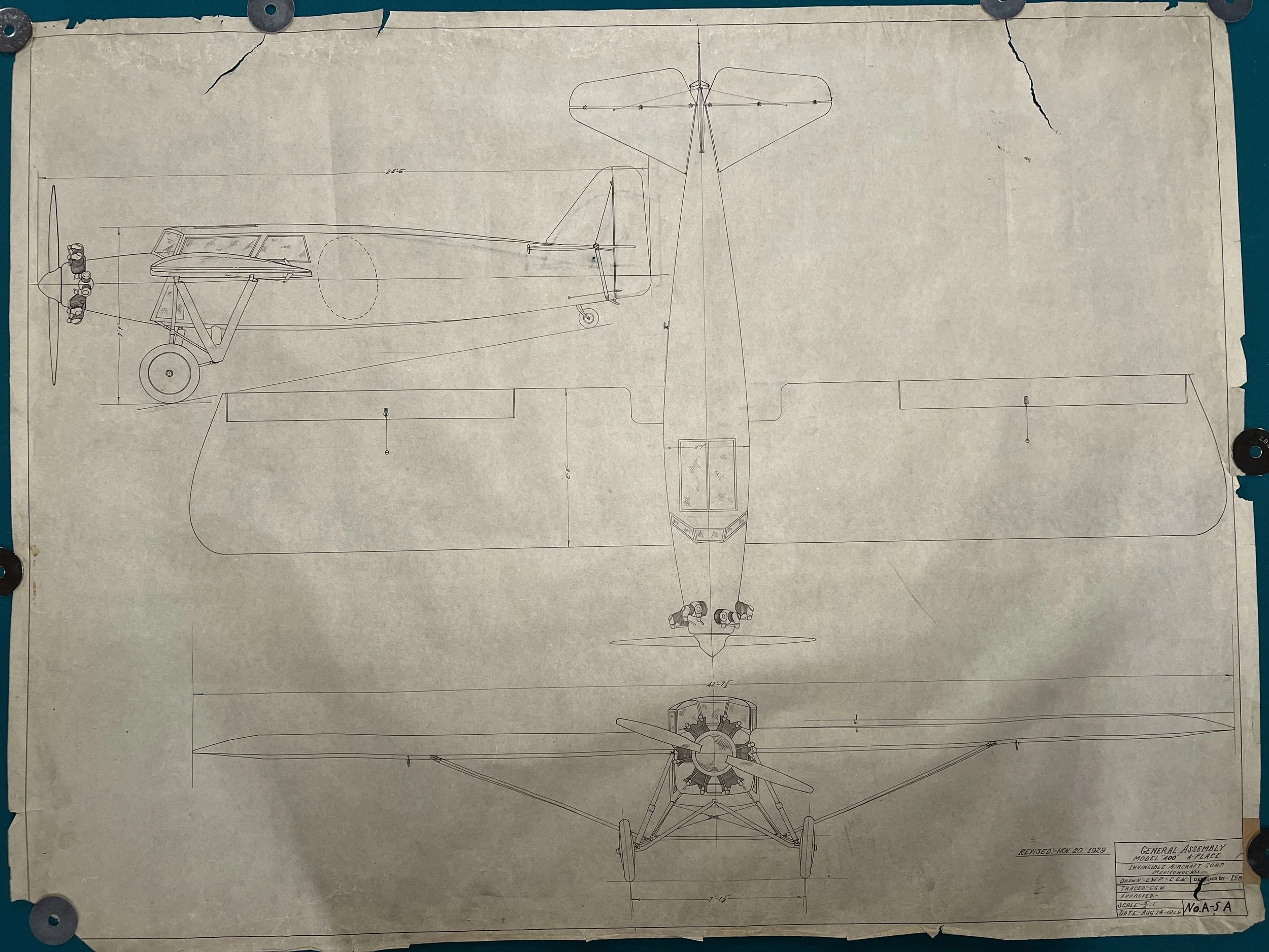 Blueprint drawing of a vintage airplane with front, side, and top views, showing detailed dimensions and mechanical features.