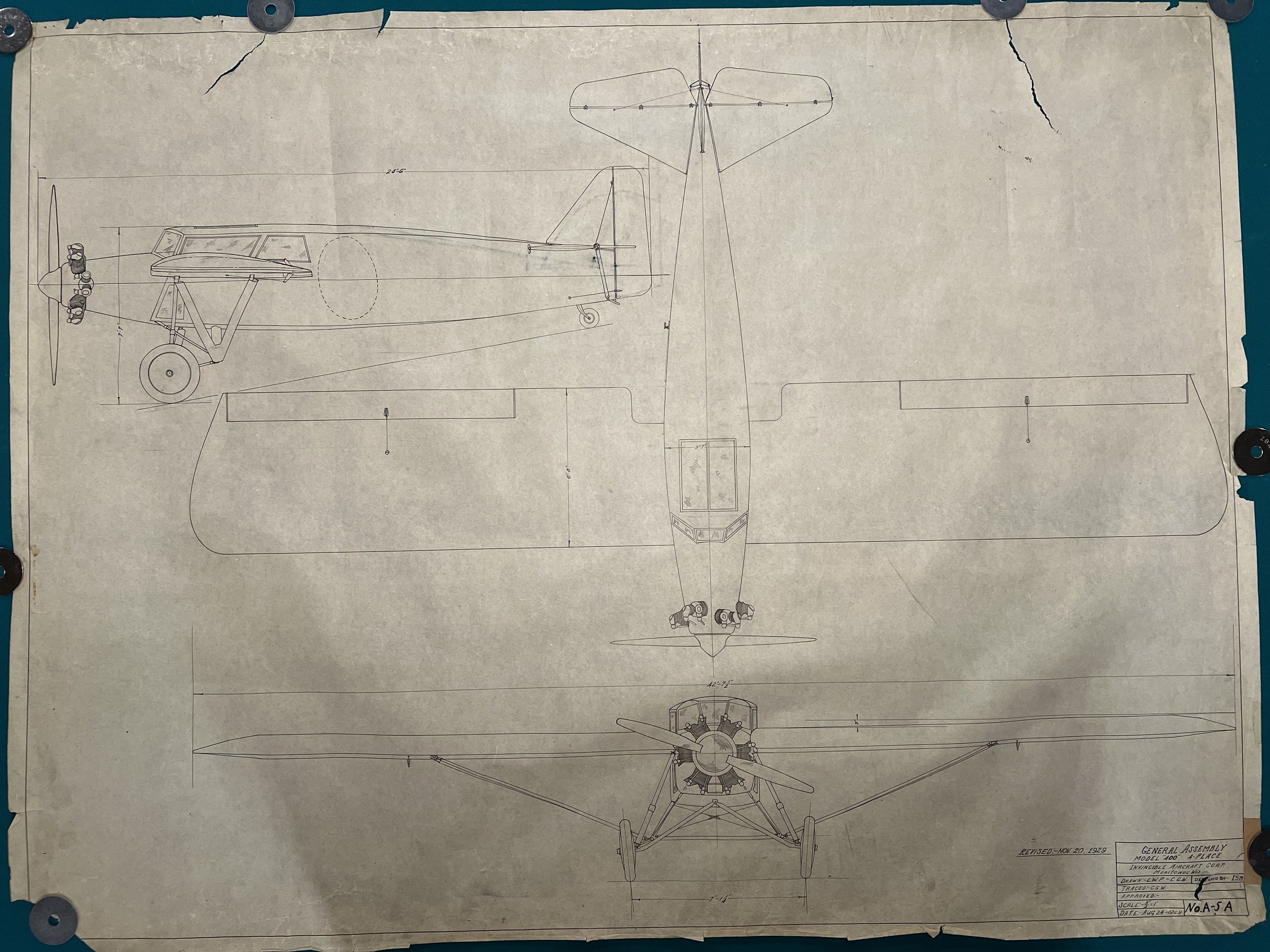 Blueprint drawing of an airplane showing top, side, and front views with notes and measurements.