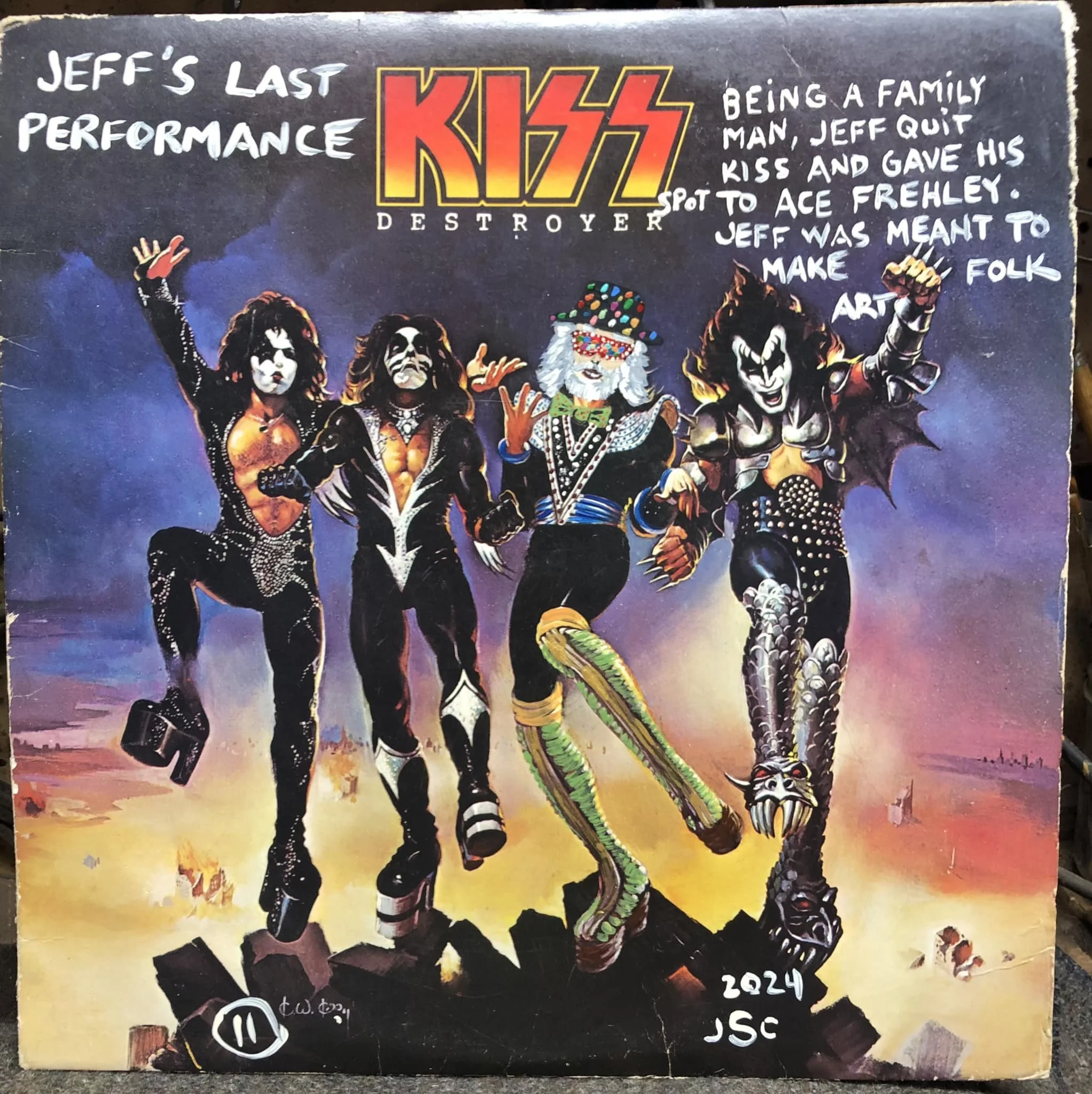 Colorful painting of the band KISS dressed in their iconic costumes, with handwritten text on a dark background.