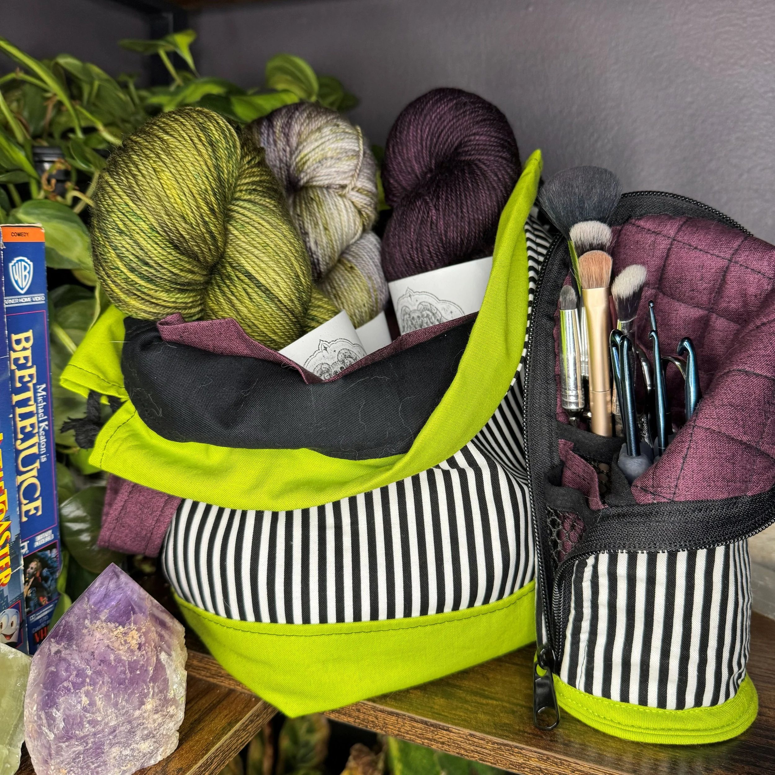 A striped sewing kit with knitting yarns and a patch of amethyst crystal.