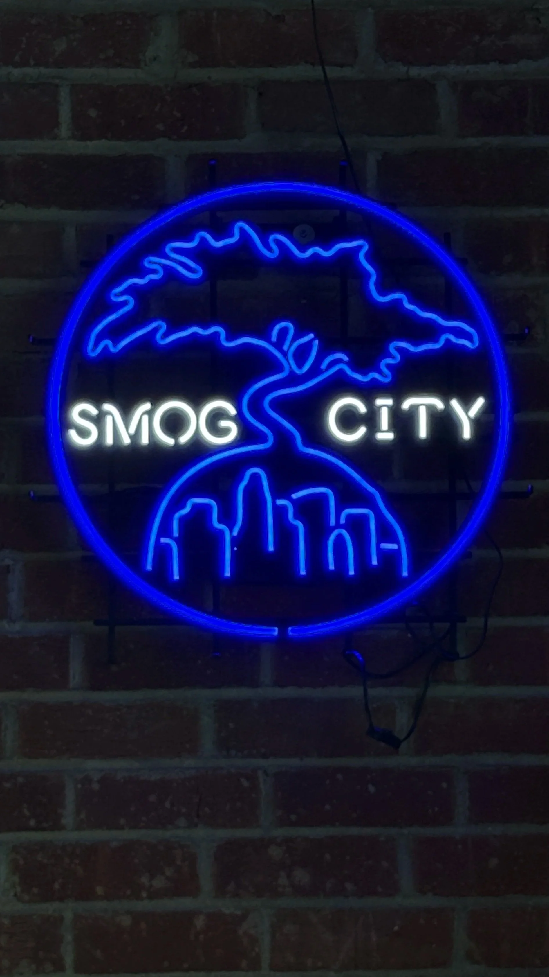 Smog City neon sign in blue and white.