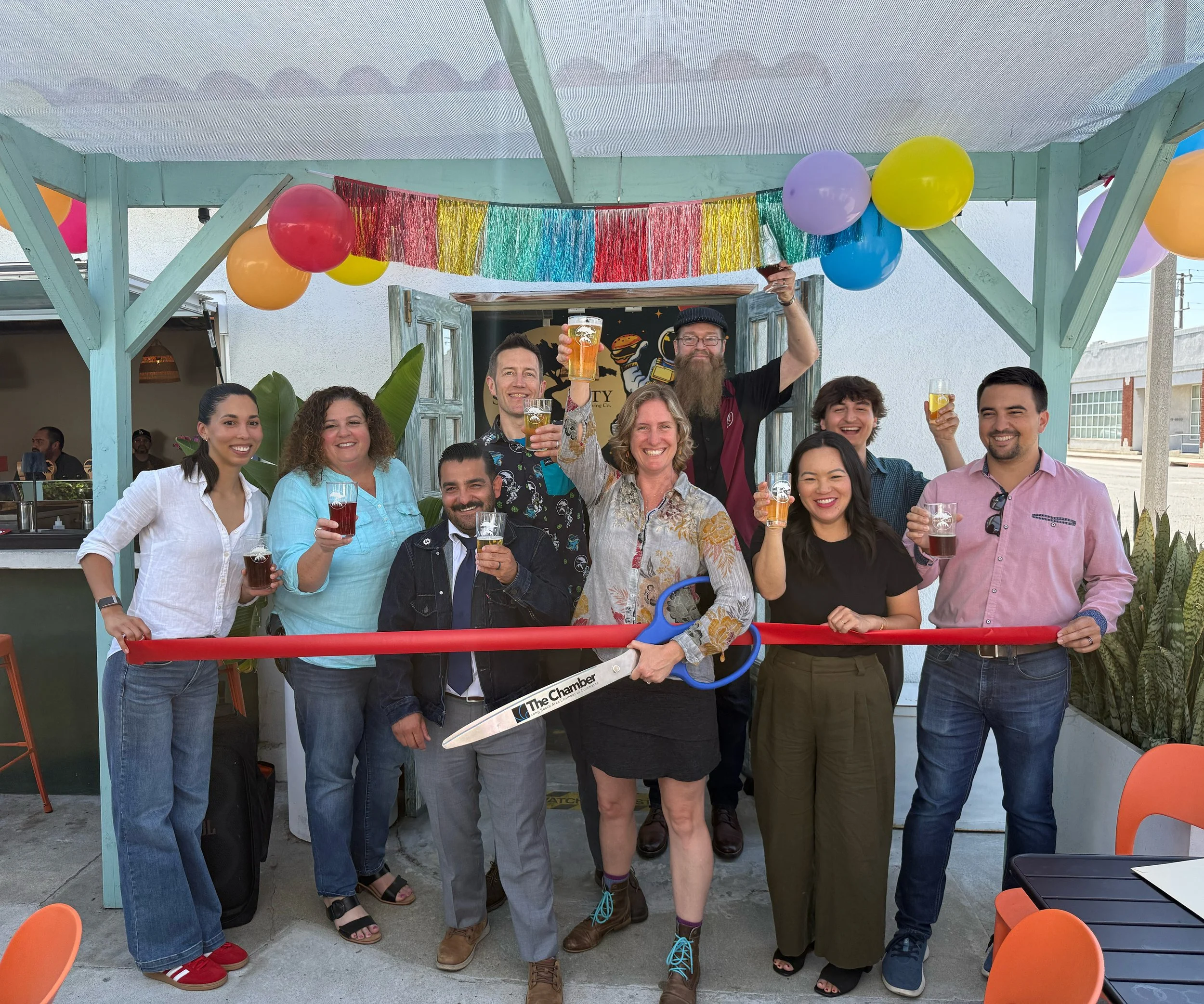 Owners and employees of Smog City Heights raising a beer with members of the Long Beach Chamber of Commerce at a ribbon cutting.