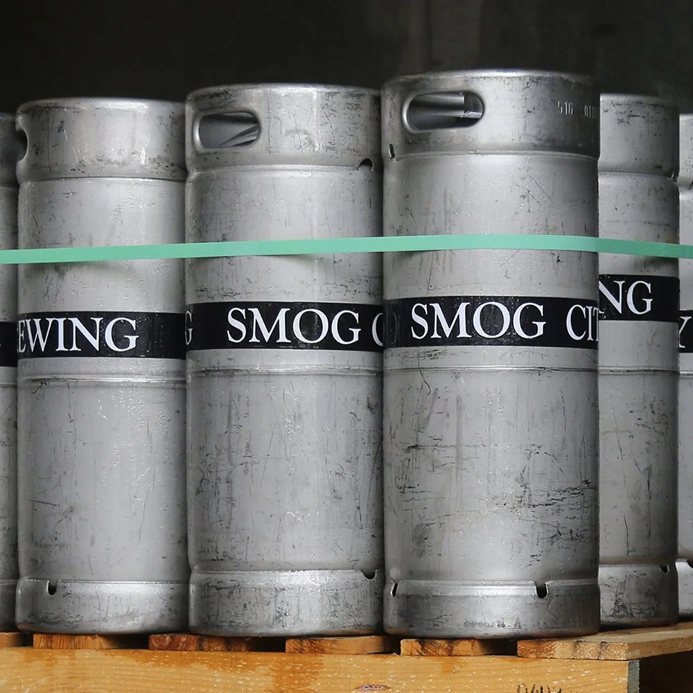 Group of 1/6 barrel Smog City Brewing Co. kegs on top of a wood pallet.