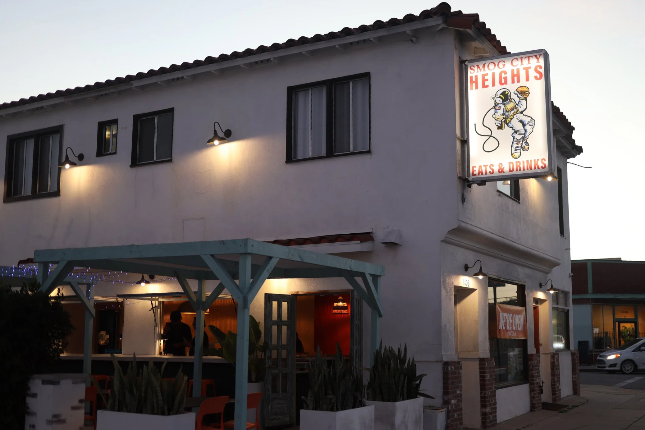 Exterior view of Smog City Heights, showing the front door, sign, and outdoor patio.