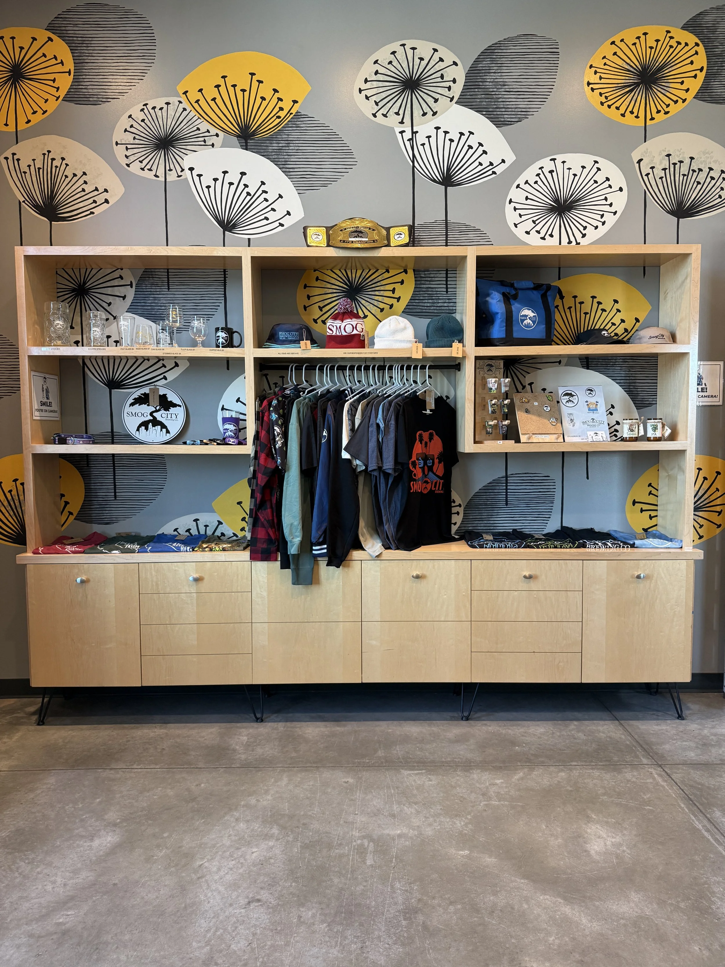 Inside of a gift shop with t-shirts, hats, and bags.
