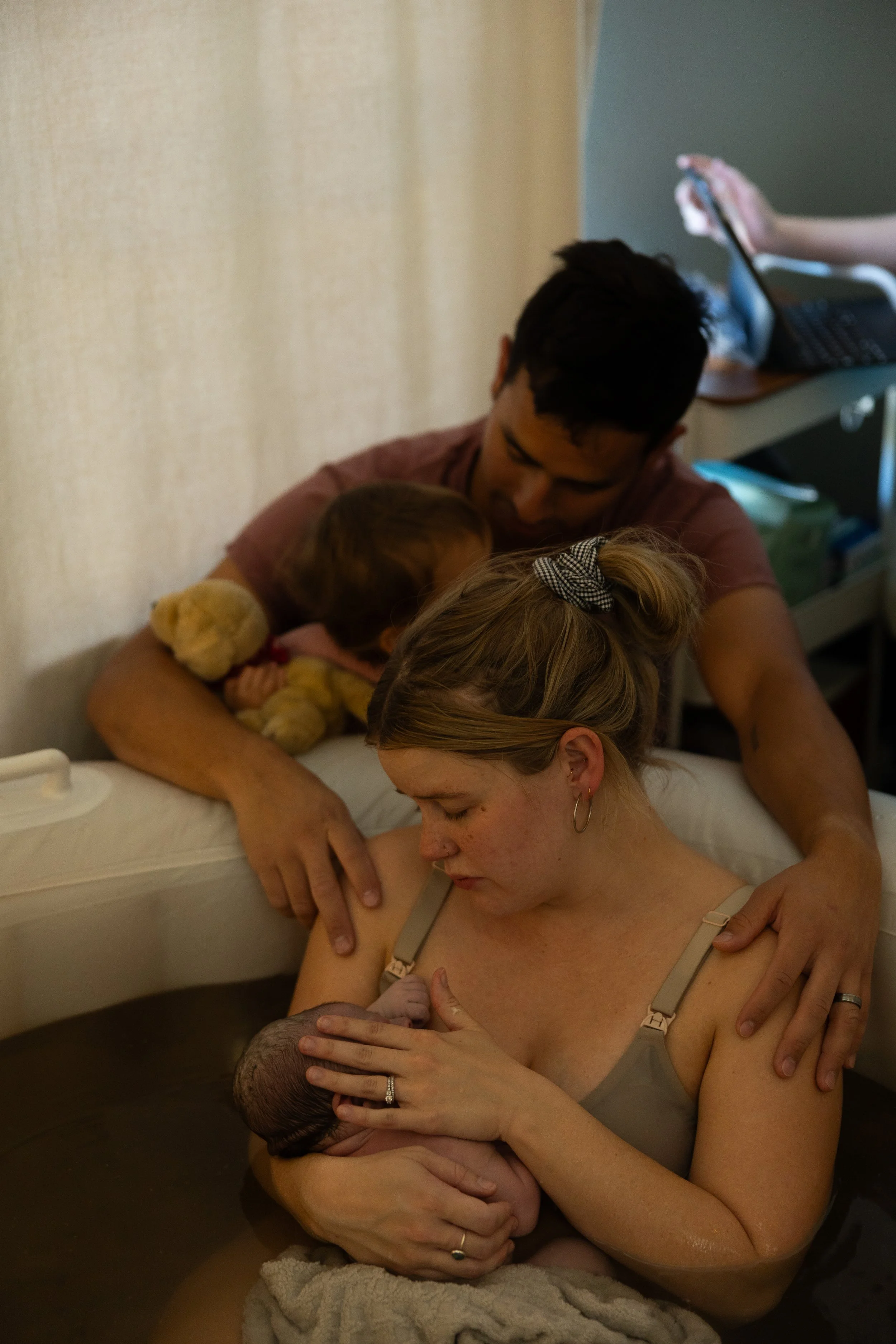 A family looks at their newborn who was just born at home in the water in Lubbock Texas.