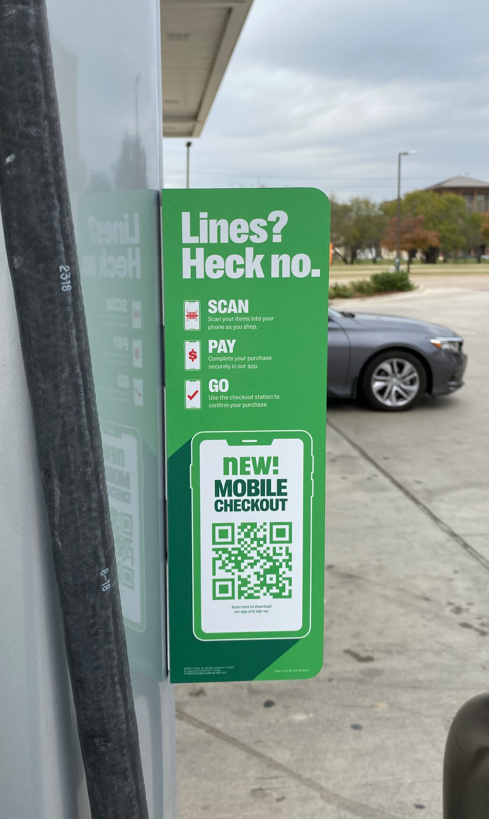Sign at a store parking lot advertising mobile checkout via QR code, with instructions to scan, pay, and go.