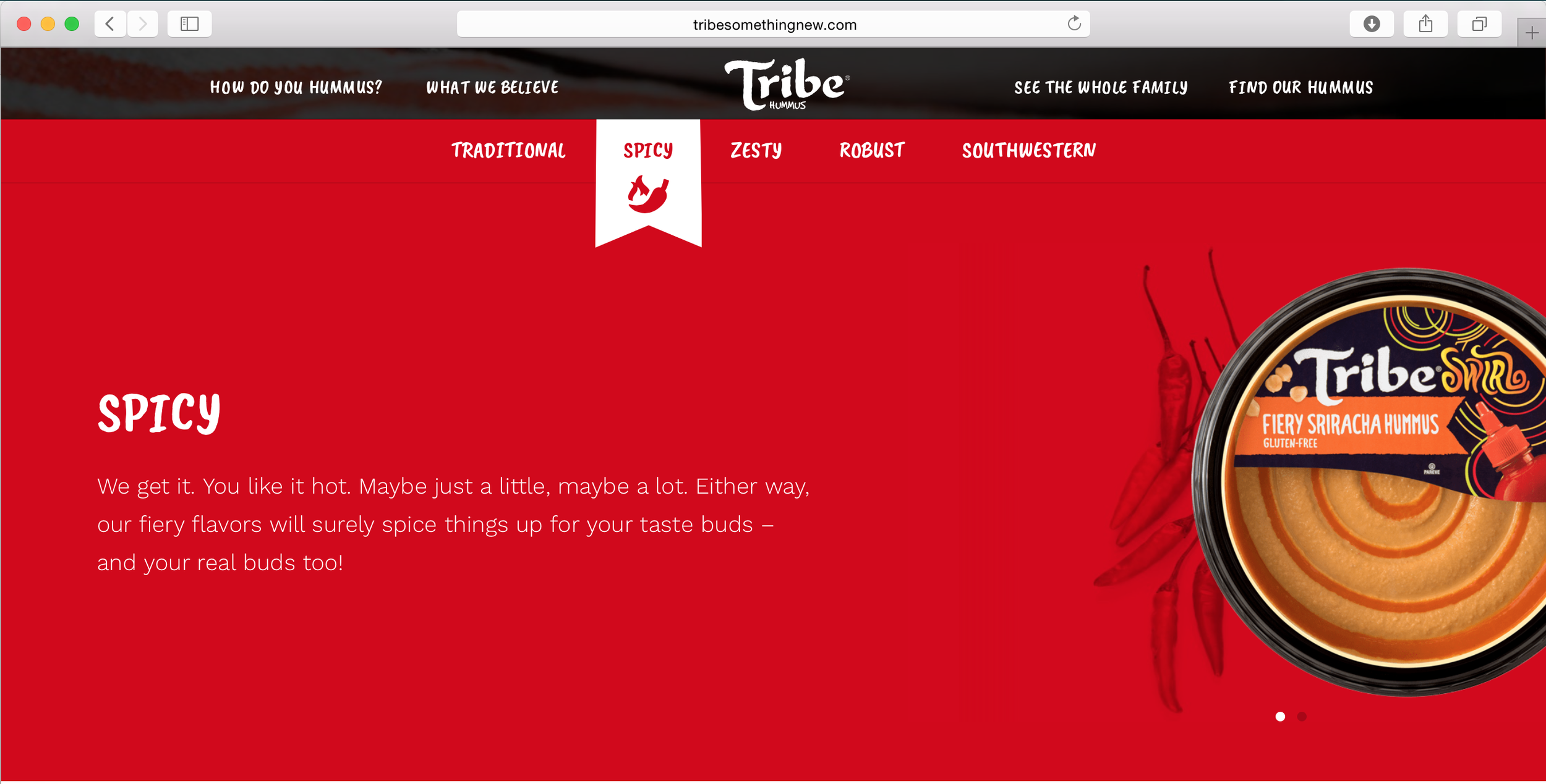 A webpage featuring a red background with a container showing a container of Tribe Fiery Sriracha Hummus and some red chili peppers. The webpage is for Tribe Hummus, with navigation options including 'How do you hummus?', 'What we believe', 'See the whole family', and 'Find our hummus'. The section is titled 'Spicy' with descriptive text about spicy flavors.