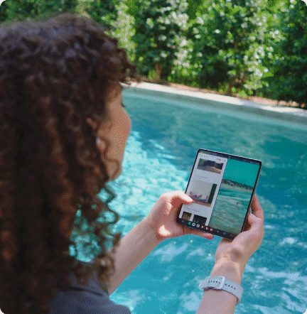 Person with curly hair taking photos of a swimming pool with a smartphone
