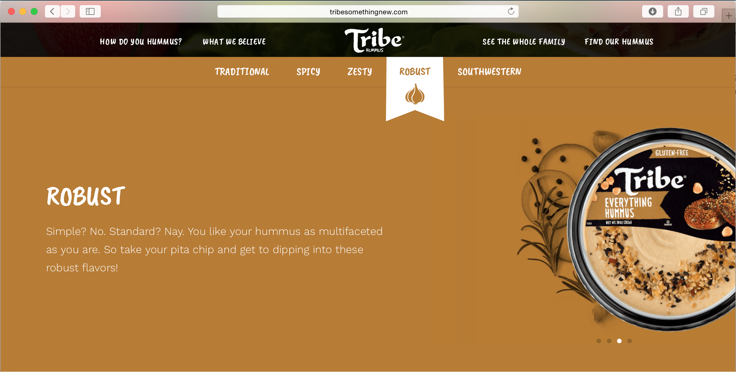 Packaging of Tribe Everything Hummus, labeled gluten-free, with a large beige hummus dip garnished with seeds and herbs, set against a brown background with decorative sprigs.