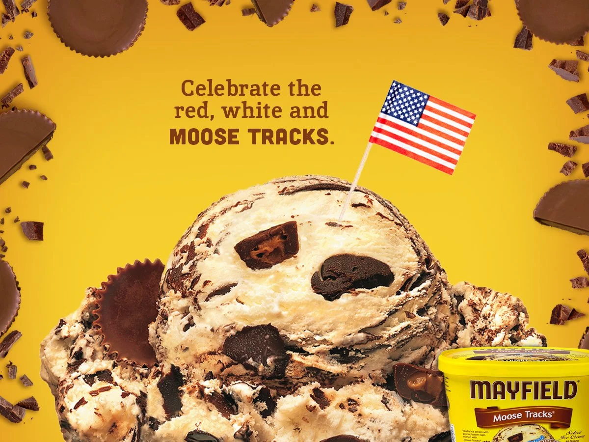 A yellow background with chocolate ice cream chunks, chocolate pieces, and the Mayfield Moose Tracks ice cream container. The text reads, "Celebrate the red, white and MOOSE TRACKS," with a small American flag on the ice cream.