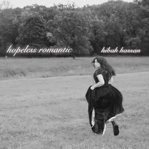 A woman in a black dress standing in an open grassy field with trees in the background. The words "hopeless romantic" and "hibah hassan" are written in cursive on the image.