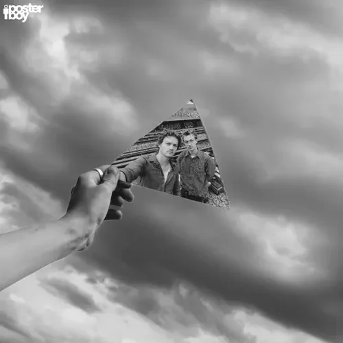 A hand holding a cut-out photograph of two men, with a cloudy sky in the background.
