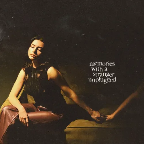 Young woman sitting with closed eyes, holding a stick, with text that reads 'memories with a stranger unplugged' beside her.