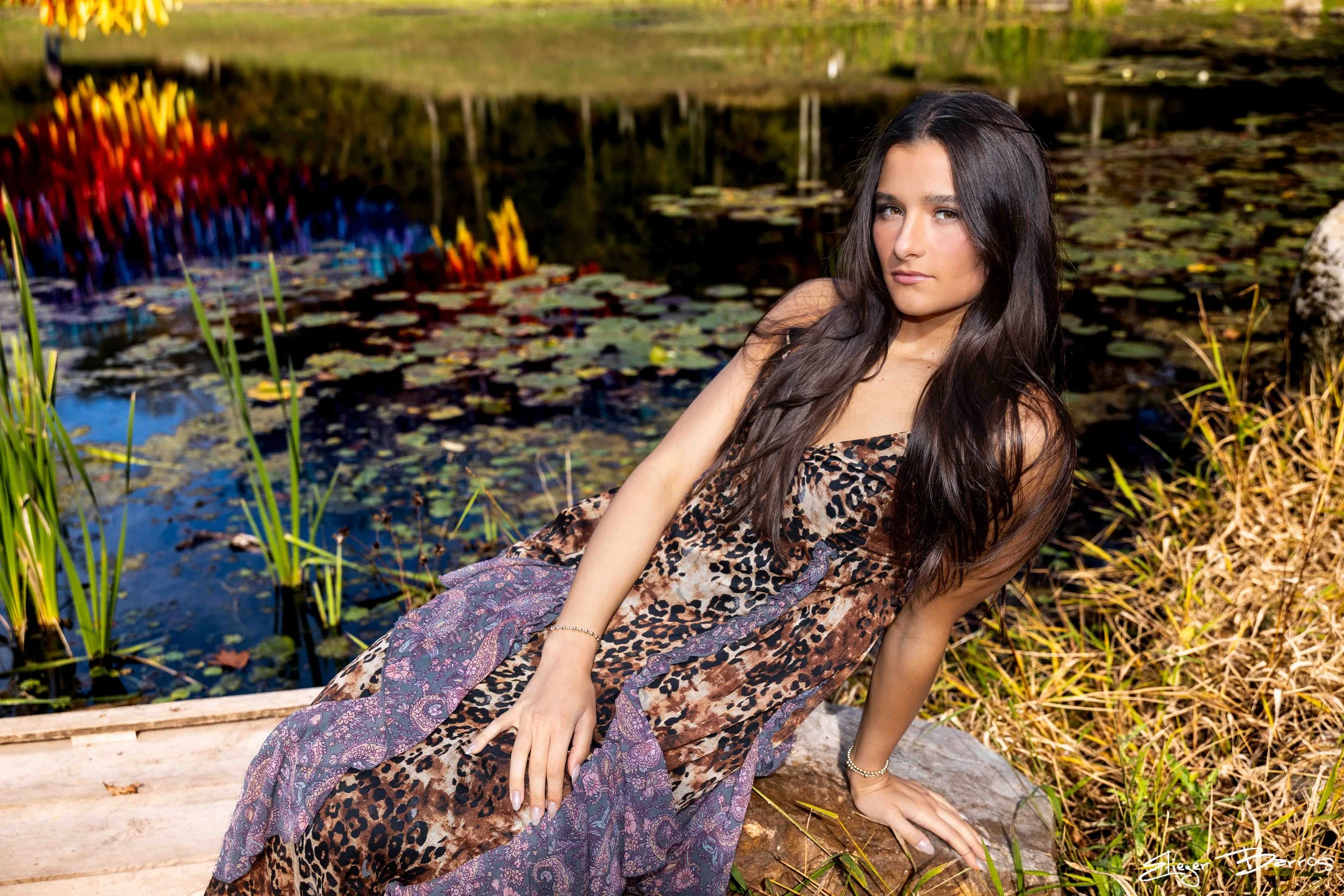 Class of 2026 senior Gianna posing by the water at Pittsburgh Botanic Garden during her fall senior session