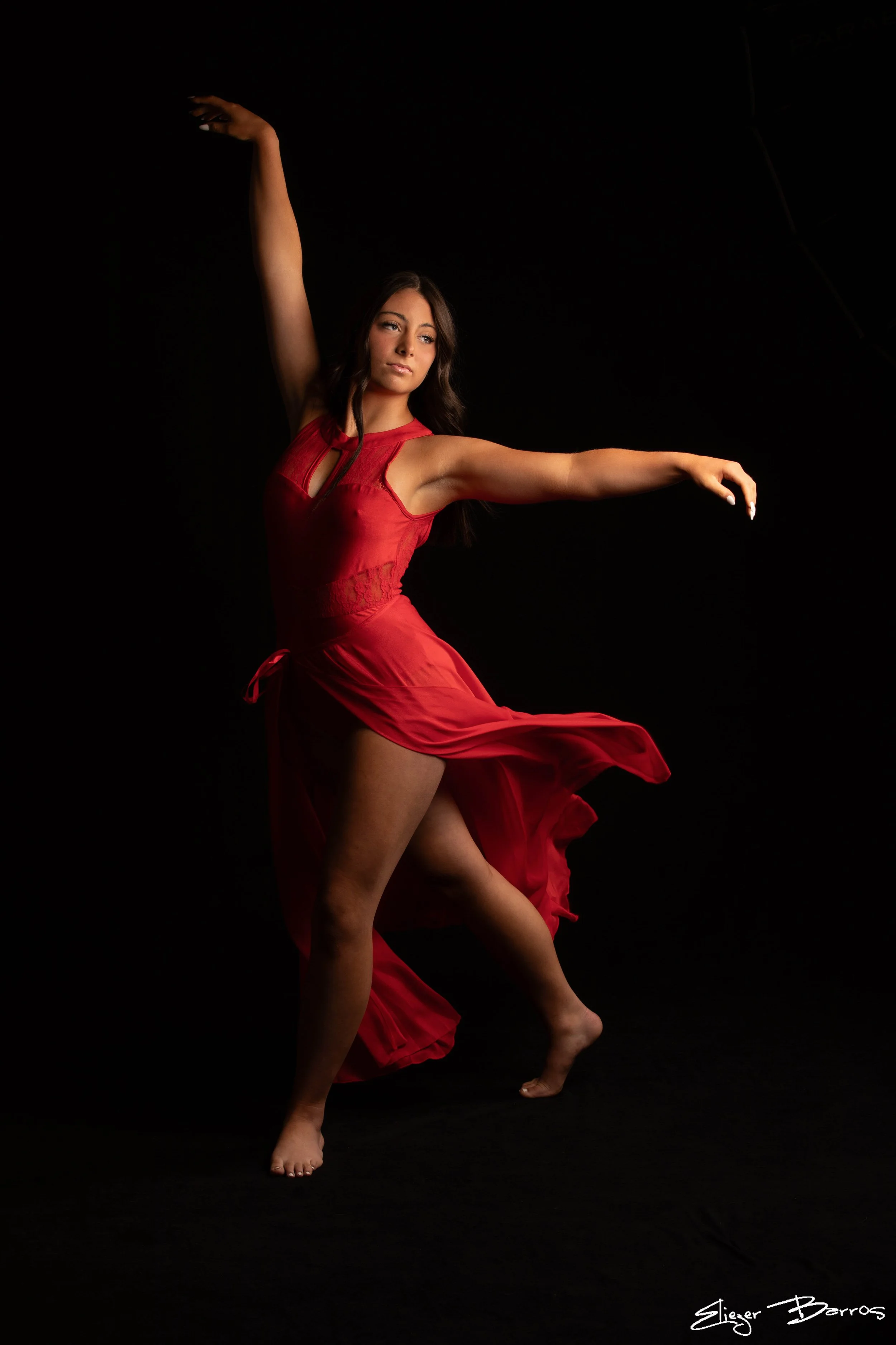 Dynamic senior pictures of a dancer in red dress performing in Pittsburgh studio