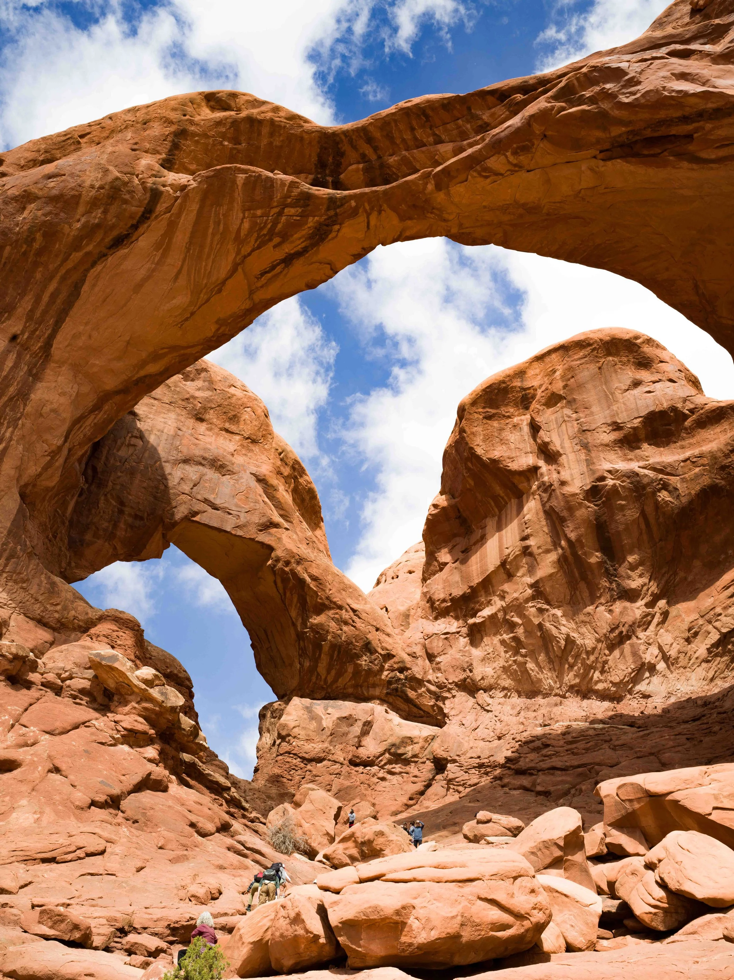 Travel photography of dramatic natural rock arch in desert landscape under blue sky