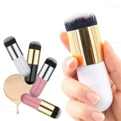 Person holding a makeup brush with gold and white handle next to several colorful makeup brushes and a swatch of foundation.