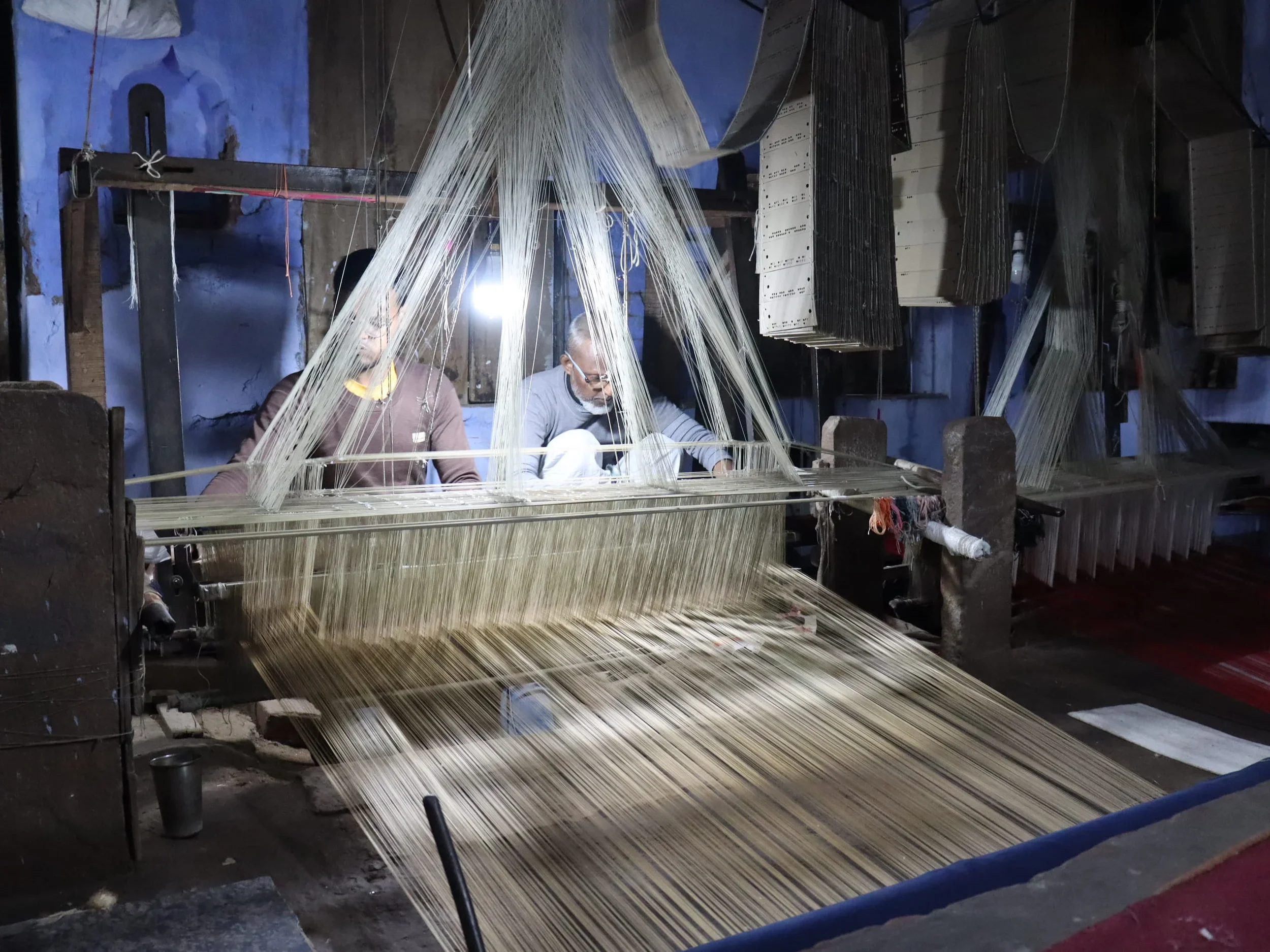 two bunkars on a handloom weaving a Banarasi Saree