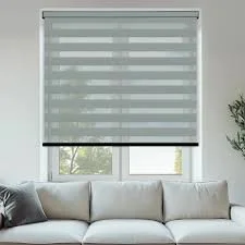 Window with a modern zebra roller blind, covering part of the window, with a white sofa and plant nearby.